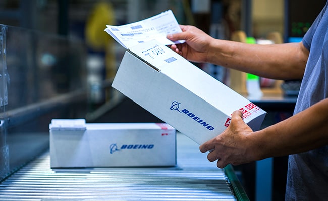 Boeing distribution employee reading package for shipment