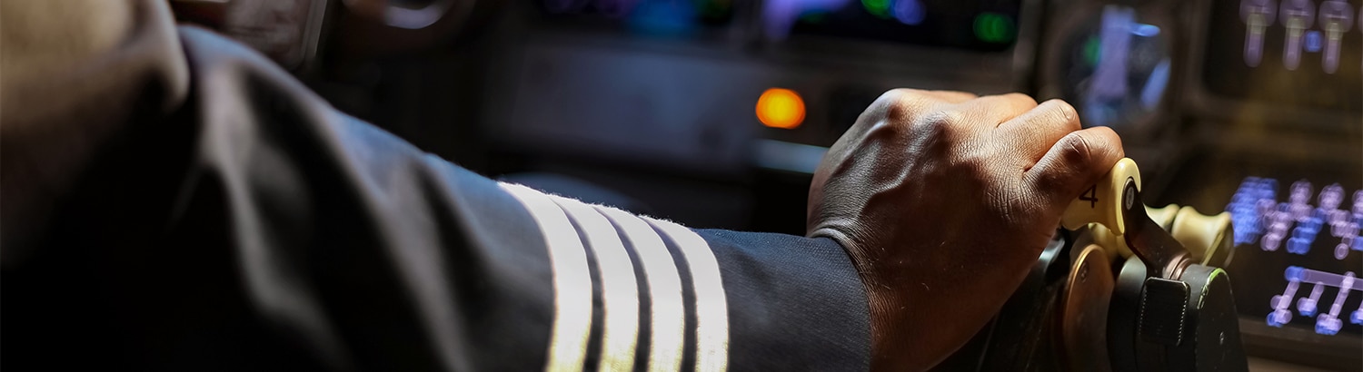 Pilot's hand flying airplane in cockpit